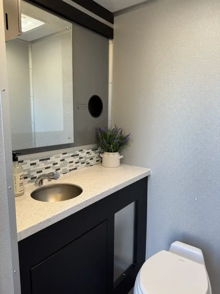 Stylish interior of a luxury restroom trailer rental with a sink and modern vanity.